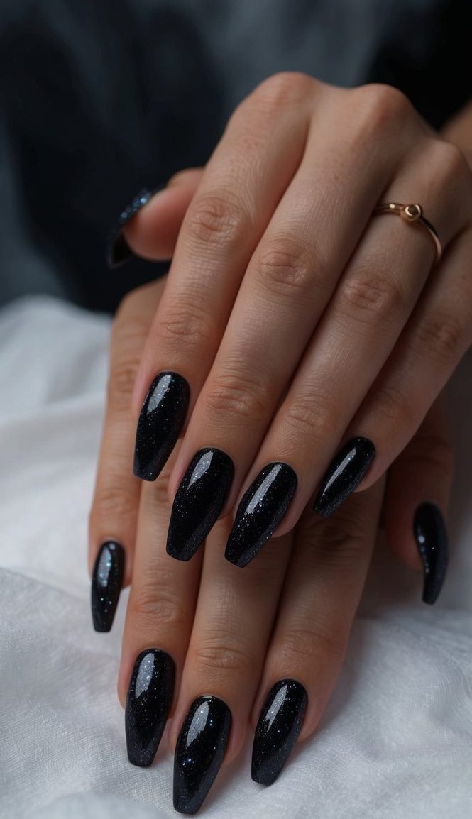 Deep, dark nails shimmering with black magic glitter, set against a mysterious and moody backdrop