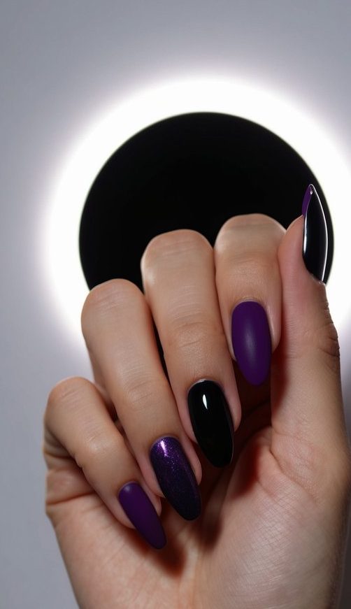 Deep purple and black nails against a dimly lit backdrop, with a faint glow resembling an eclipse