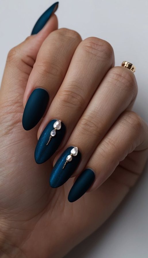 A moody wedding nail look with rich matte teal polish, enhanced by soft shimmer and adorned with small pearl drops and golden stems for a poetic, celestial effect.