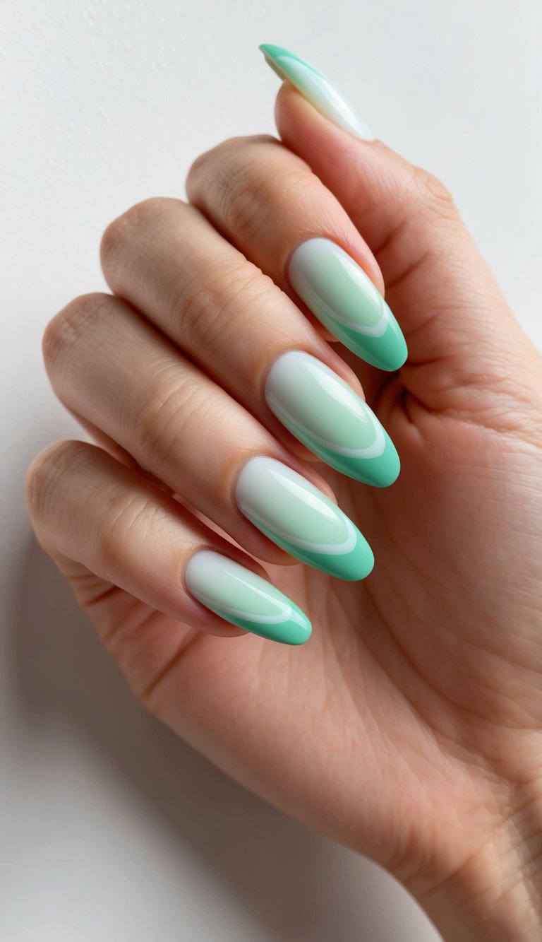 Close-up of a hand against a white wall featuring almond ombre wedding nails fading from pale white into bright mint green with a high-gloss finish.