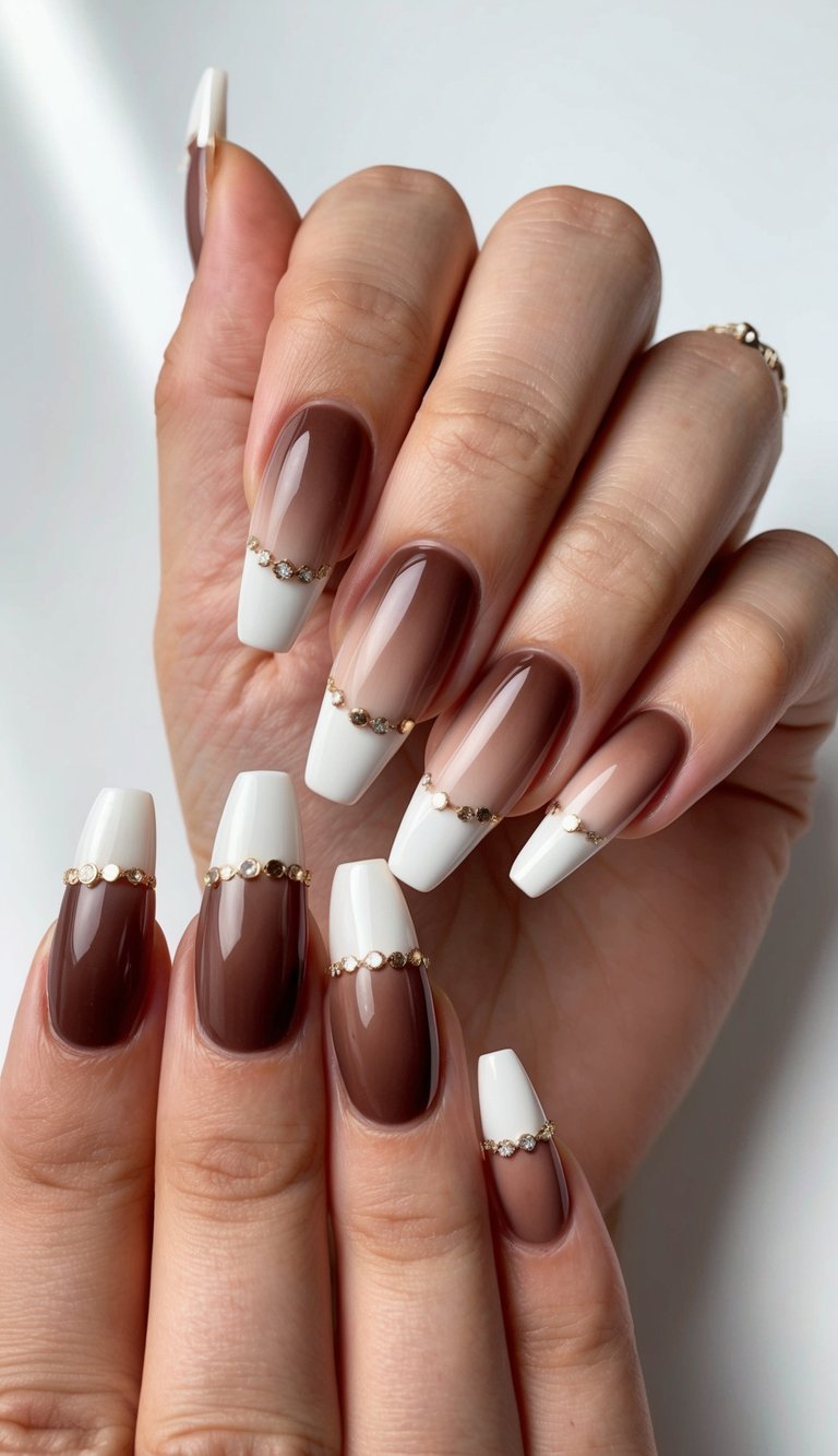 Long square ombre wedding nails shown on overlapping hands, featuring a cocoa brown to ivory fade and decorative gold crystal bands across each nail.